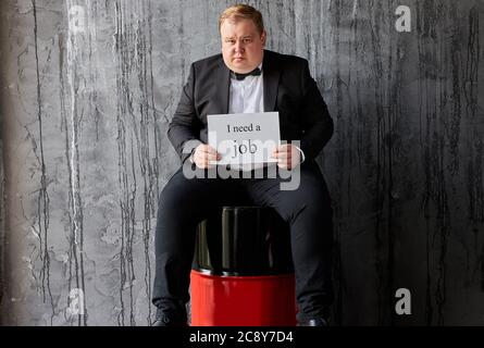 depressed fat caucasian oilman needs new job, his oil company is failed on world market, sits with barrels Stock Photo