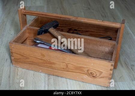 Antique wood tool box with handle and tools on wooden background Stock Photo