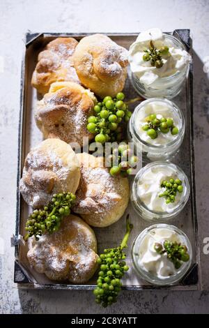 Sweet rolls with fruit and whipped cream in jars.Grape ornament.Healthy food and drink. Stock Photo