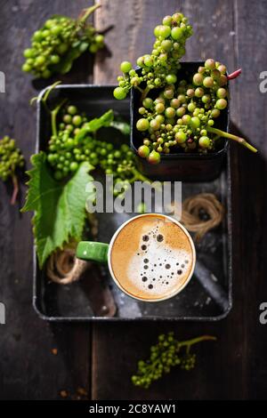 Morning coffee with milk.Espresso with a delicious grape.Dark background.Sweet food and drink. Stock Photo