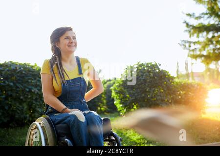 beautiful disabled girl looking up, looking at the bright side of life, woman gets pleasure from the beauty of nature, landscape. copy space Stock Photo