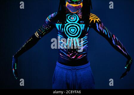 young african man blur with ultraviolet body art, fluorescent prints glows  on neon light, isolated in studio. mystery, luminescence, fluorescence, eth  Stock Photo - Alamy