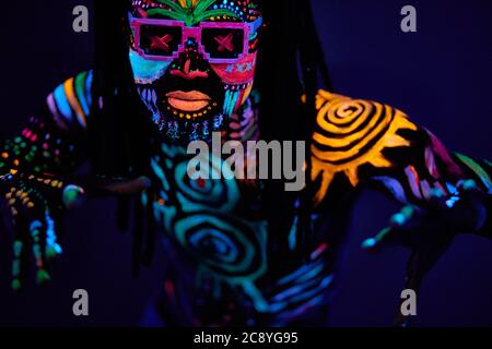 portrait of young unrecognizable man in sunglases with fluorescent prints on skin, cool handsome fashionable guy posing at camera Stock Photo