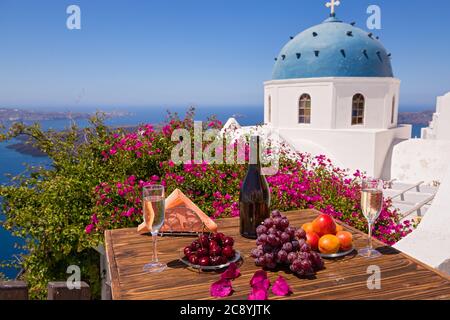 Wine and fruit for two on the table against the backdrop of the sea of Santorini Stock Photo