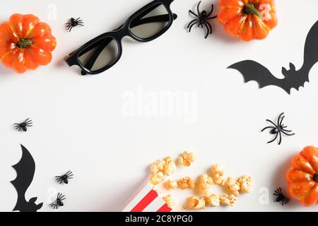 Halloween party, watching scary movie at night concept. Flat lay composition with pumpkins, popcorn, bats, spiders, glasses on white table. Halloween Stock Photo