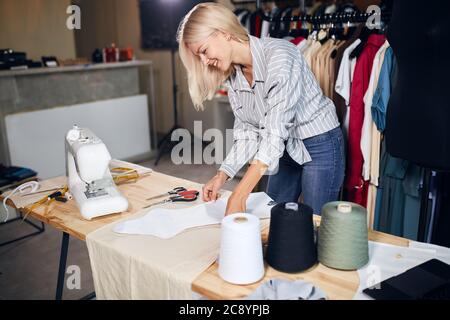 cheerful tailor going to sew a dress for a client. business concept, side view photo Stock Photo