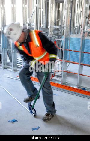 A motion blurred image of an electricial bending a steel conduit,  Focus on the conduit bender and conduit. Stock Photo