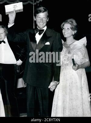 Jul. 5, 1973 - London, England, United Kingdom -The royal premiere of the new James Bond Film 'Live and Let Die' was held at the Odeon Theater Leicester Square. Film star ROGER MOORE arrives for the premiere with his wife, LUISA MATTIOLI. MICHAEL ATTENBOROUGH, is seen background left. (Credit Image: © Keystone Press Agency/Keystone USA via ZUMAPRESS.com) Stock Photo