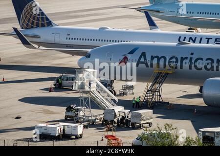 Boeing aircrafts serviced by ground handling crews awaiting the next scheduled flight while on the remote area of Sao Paulo/Guarulhos Intl. Airport. Stock Photo