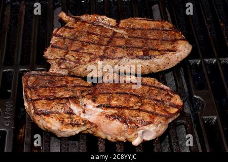 Sirloin steaks cooking on the grill are the highlight of a great summer day. Stock Photo