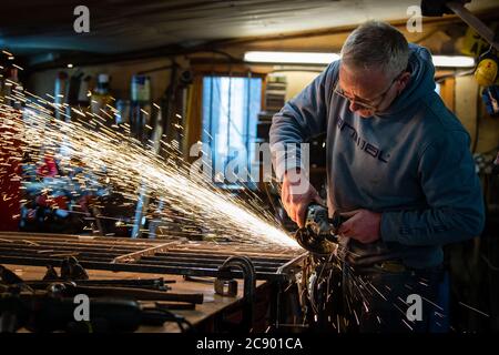 The Blazing Blacksmith Jim Whitson working on a garden gate in his workshop at Waterheads near Eddleston Stock Photo