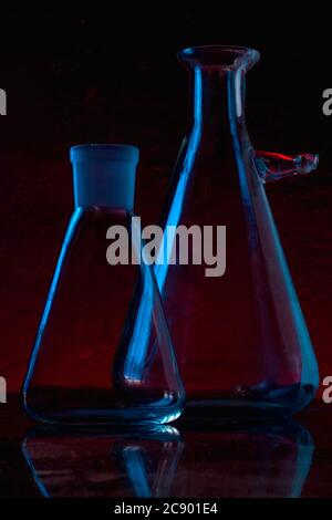 Low-key Studio Shot of a blue silhouette of a chemical laboratory utensils light glasses isolated on a black Background. Smooth lines and shapes. Concept. Stock Photo