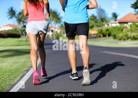 Runners running on road - closeup of legs of athletes sprinting training cardio together Stock Photo