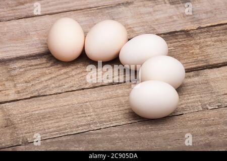 The eggs, the top view which are laid out by a half moon on a wooden table from old boards, nobody. Stock Photo