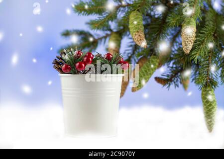 Christmas background. Christmas and New Years holidays. spruce branches and pine cones. White bucket with red berries. copyspace Stock Photo