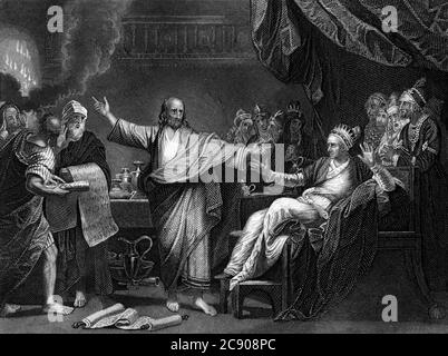 An engraved Old Testament Bible illustration image of Daniel Interpreting The Writing On The Wall from a vintage Victorian bible dated 1852 that is no Stock Photo