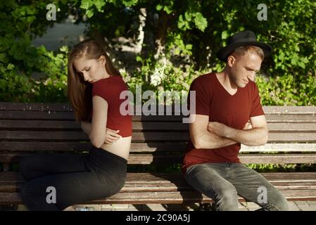 A couple is breaking up. The boy and girl is siting back to each other. Stock Photo