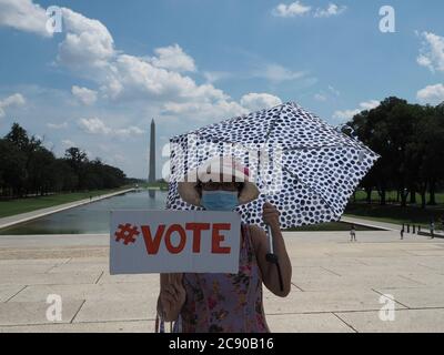 Washington, District of Columbia, USA. 27th July, 2020. Shading herself from the dayÃs heat, a woman awaits the passage of the hearse carrying the late Rep. John Lewis. Credit: Sue Dorfman/ZUMA Wire/Alamy Live News Stock Photo