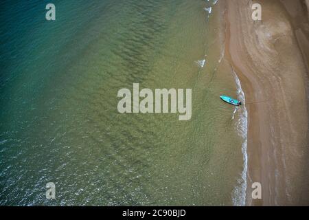 This unique photo shows the beach of Pak Nam Pran in Thailand photographed from above with a fishing boat that is anchored on the beach. Stock Photo