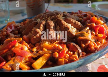 couscous with peppers, chickpeas, onions and lamb sausages Stock Photo