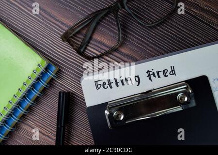 Getting Fired text write on a book isolated wooden table. Stock Photo