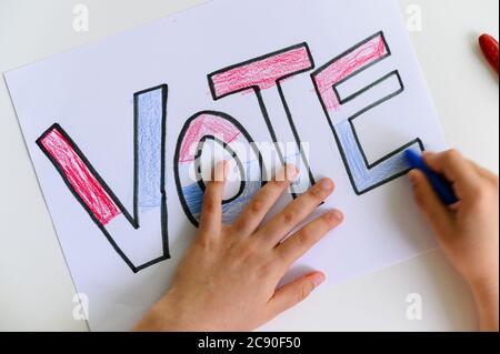 Child's hands coloring Vote sign Stock Photo