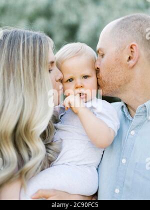 Parents kissing baby boy son Stock Photo
