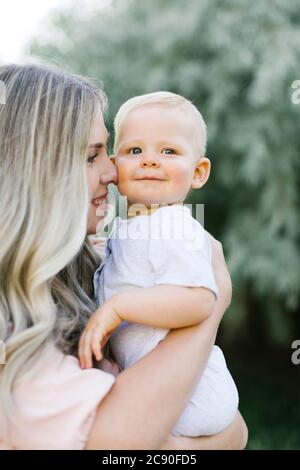 Outdoor portrait of mother holding baby son Stock Photo