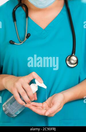 Female hospital worker using hand sanitizer Stock Photo