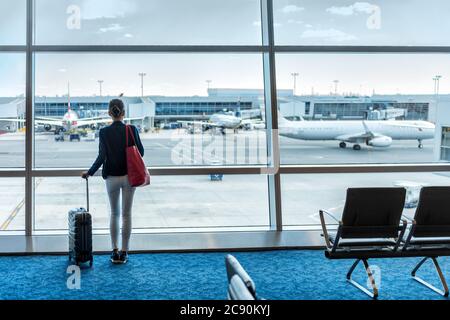 Travel tourist woman with luggage at airport Stock Photo