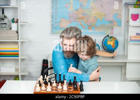 Games good for brain intelligence concept. Intelligent kids. Pupil kid thinking about his next move in a game of chess. Educational games. Stock Photo