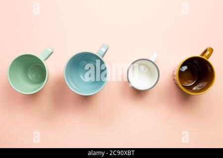 Colorful empty mug cups on pink background. top view Stock Photo