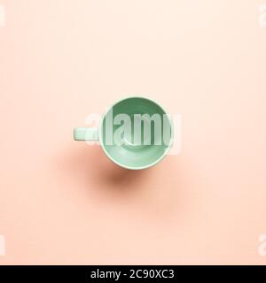 Green empty mug cup on pink background. top view Stock Photo