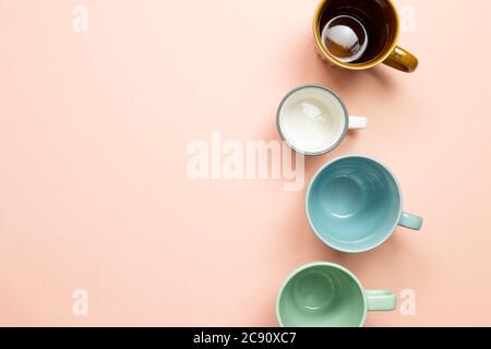 Colorful empty mug cups on pink background. top view Stock Photo