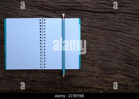 Pencil on top of book on the old wood desk at the background Stock Photo