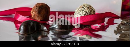 home-made chocolate candy, also know as chocolate bon-bons, lay on a silver foil background Stock Photo