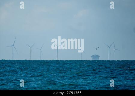Worthing Beach, Worthing, UK. 28th July, 2020. Rampion Offshore Wind Farm early on a clear morning. Built by EON The wind farm comprises 116 turbines on a 70 square kilometre site located between 13 and 20 kilometres off the Sussex coast in the English Channel. Picture by Credit: Julie Edwards/Alamy Live News Stock Photo