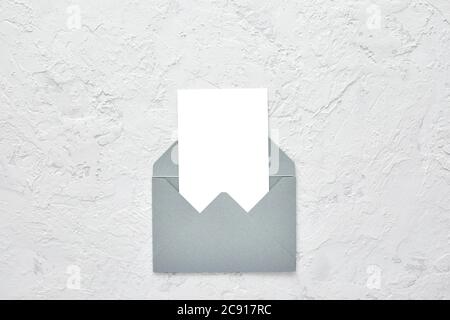 white blank card in gray envelope on cement texture background. mockup. Top view. Stock Photo