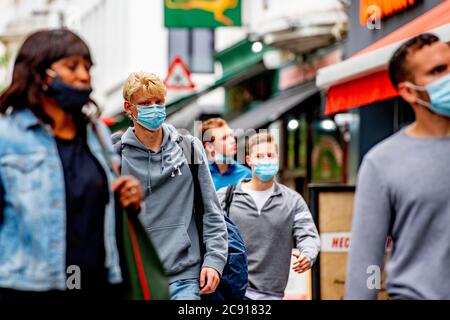 Antwerp, Belgium. 27th July, 2020. People wearing face masks as a preventive measure walk on the street during the coronavirus crisis.The wearing of a face mask will become compulsory from Saturday in shops and some other indoor spaces where people gather. Credit: SOPA Images Limited/Alamy Live News Stock Photo