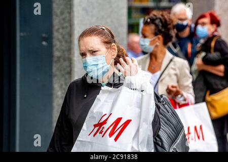 Antwerp, Belgium. 27th July, 2020. Shoppers wearing face masks as a preventive measure walk on the street during the coronavirus crisis.The wearing of a face mask will become compulsory from Saturday in shops and some other indoor spaces where people gather. Credit: SOPA Images Limited/Alamy Live News Stock Photo