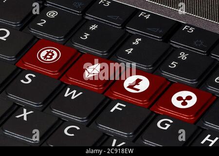 Computer keyboard with symbols of the most popular crypto currencies on the keys and color accent. Concept of cryptocurrency and block chain technolog Stock Photo