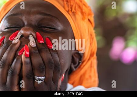 African woman holding her mouth with her hands Stock Photo
