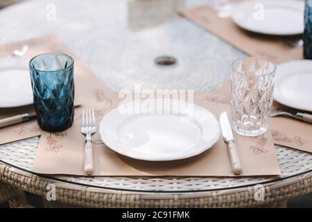 Close up of Served table set at summer terrace. Cutlery in cafe. Blue glasses Stock Photo