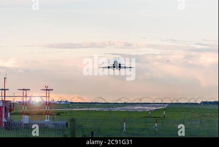 The plane taking off at the airport in the evening Stock Photo