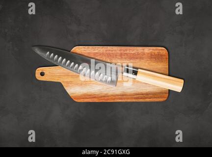 Traditional Japanese gyuto chief knife on a cutting board. Concrete background Stock Photo