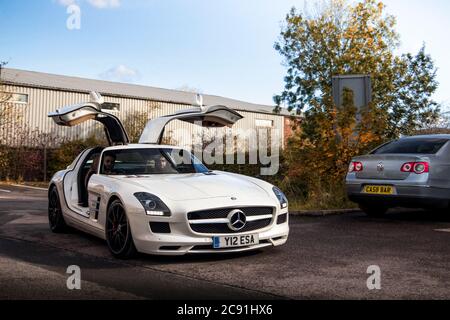 White Mercedes-Benz SLS AMG supercar with open gullwing doors arriving to a small car gathering in Birmingham. Stock Photo