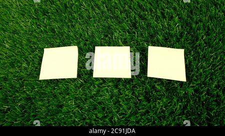 yellow stickers on green lawn close-up, copy space. Stock Photo