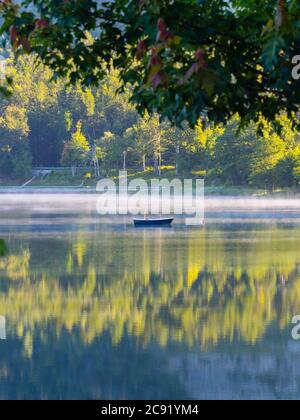 Lonesome boat on lake Bajer in Fuzine Croatia Europe fog mist vapour floating float just about water surface gorgeous & stunning & marvelous Stock Photo