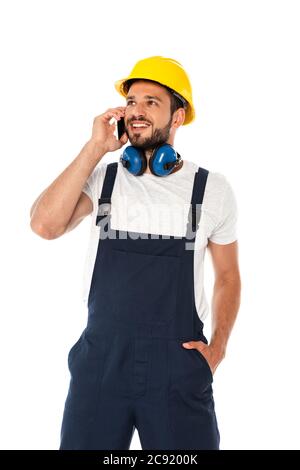Smiling repairman in overalls talking on smartphone isolated on white Stock Photo