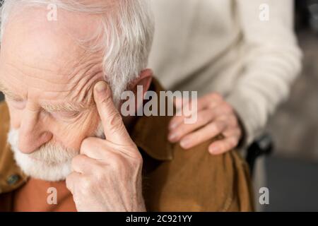 cropped view of woman touching shoulder of husband sick on